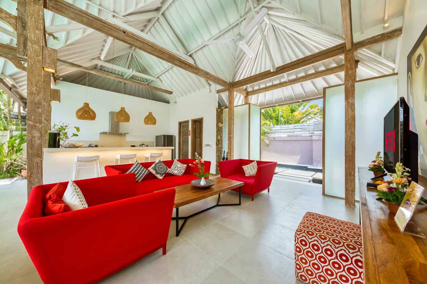 Modern living room with red sofas and open kitchen.
