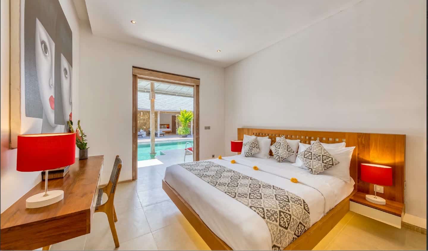 Spacious bedroom with pool view and modern decor.