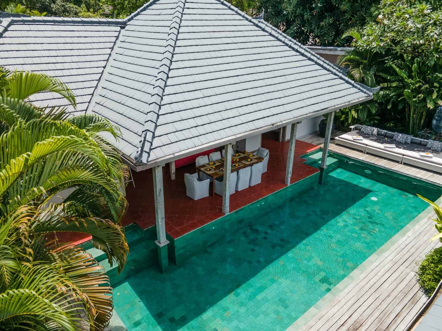 Tropical villa with pool and outdoor dining area.