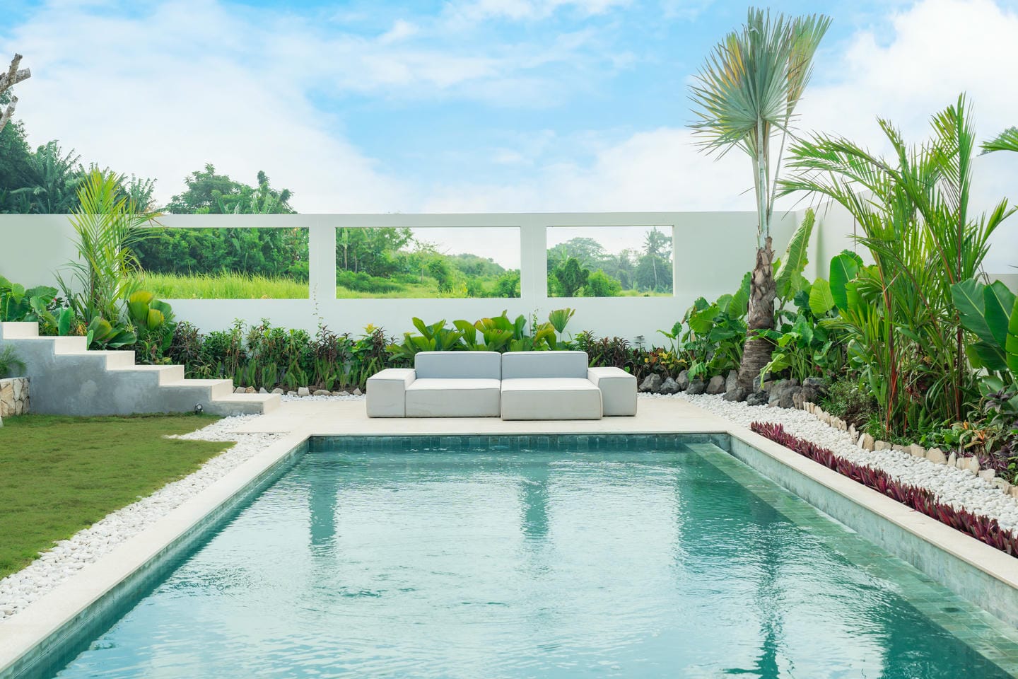 Modern poolside with tropical garden and seating