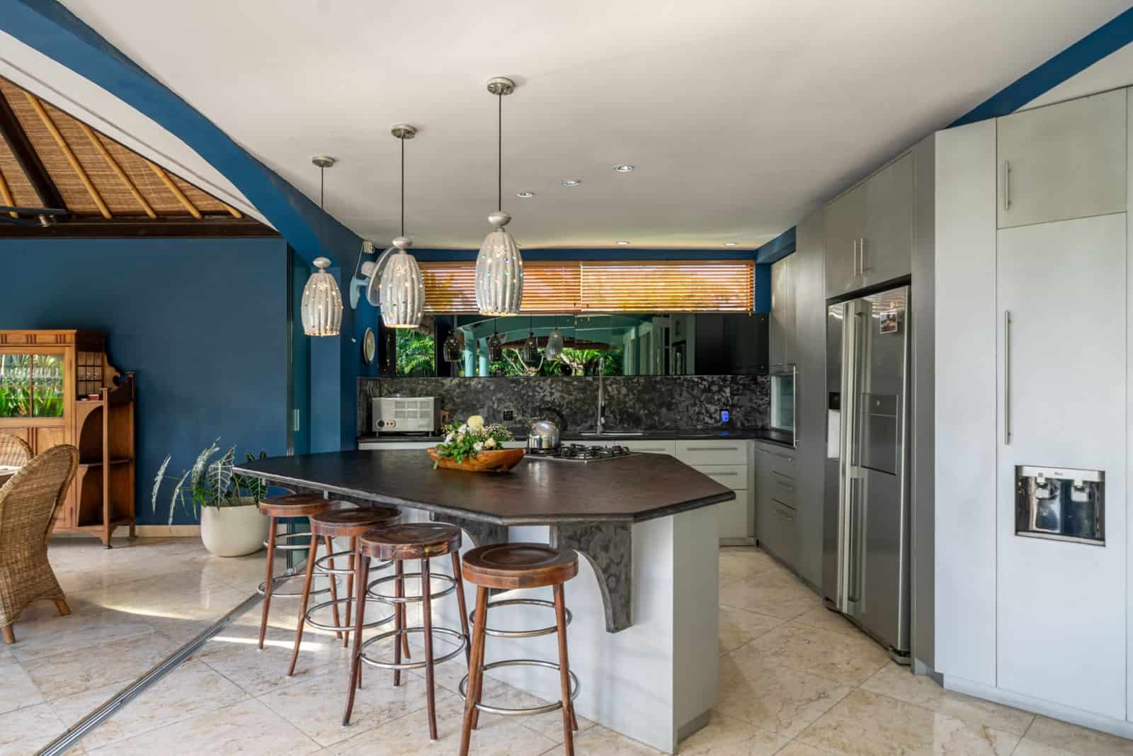 Modern kitchen with blue walls and island seating.