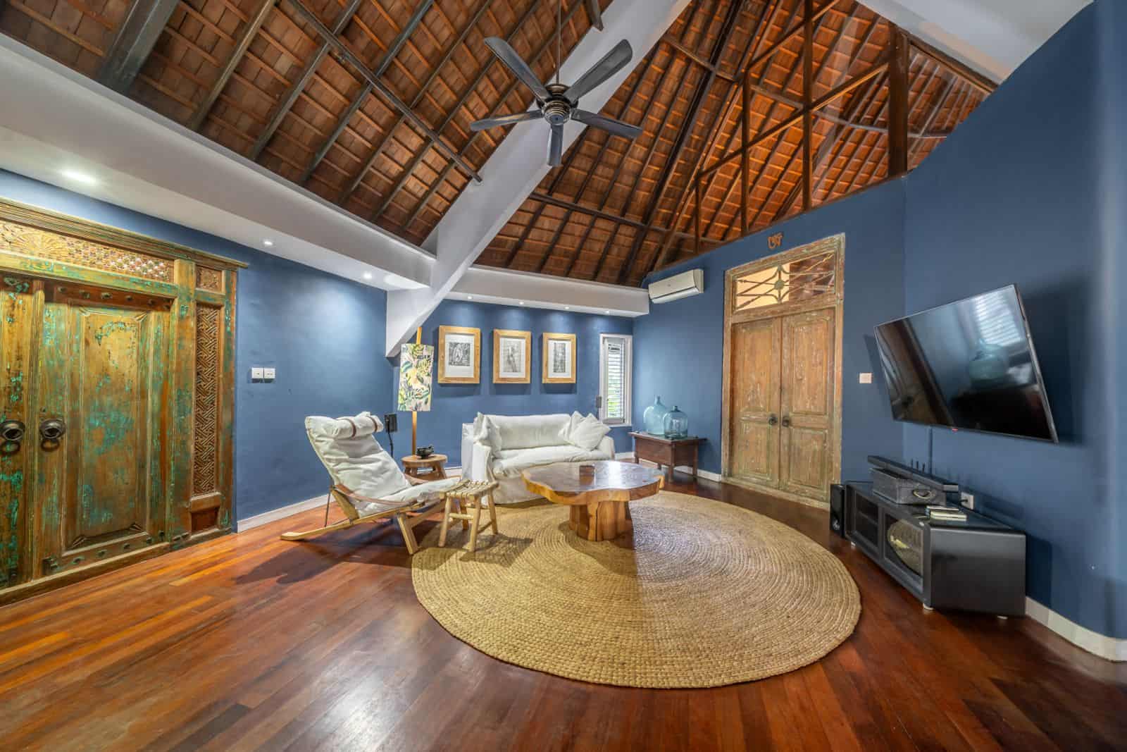 Rustic living room with wooden ceiling and furniture.