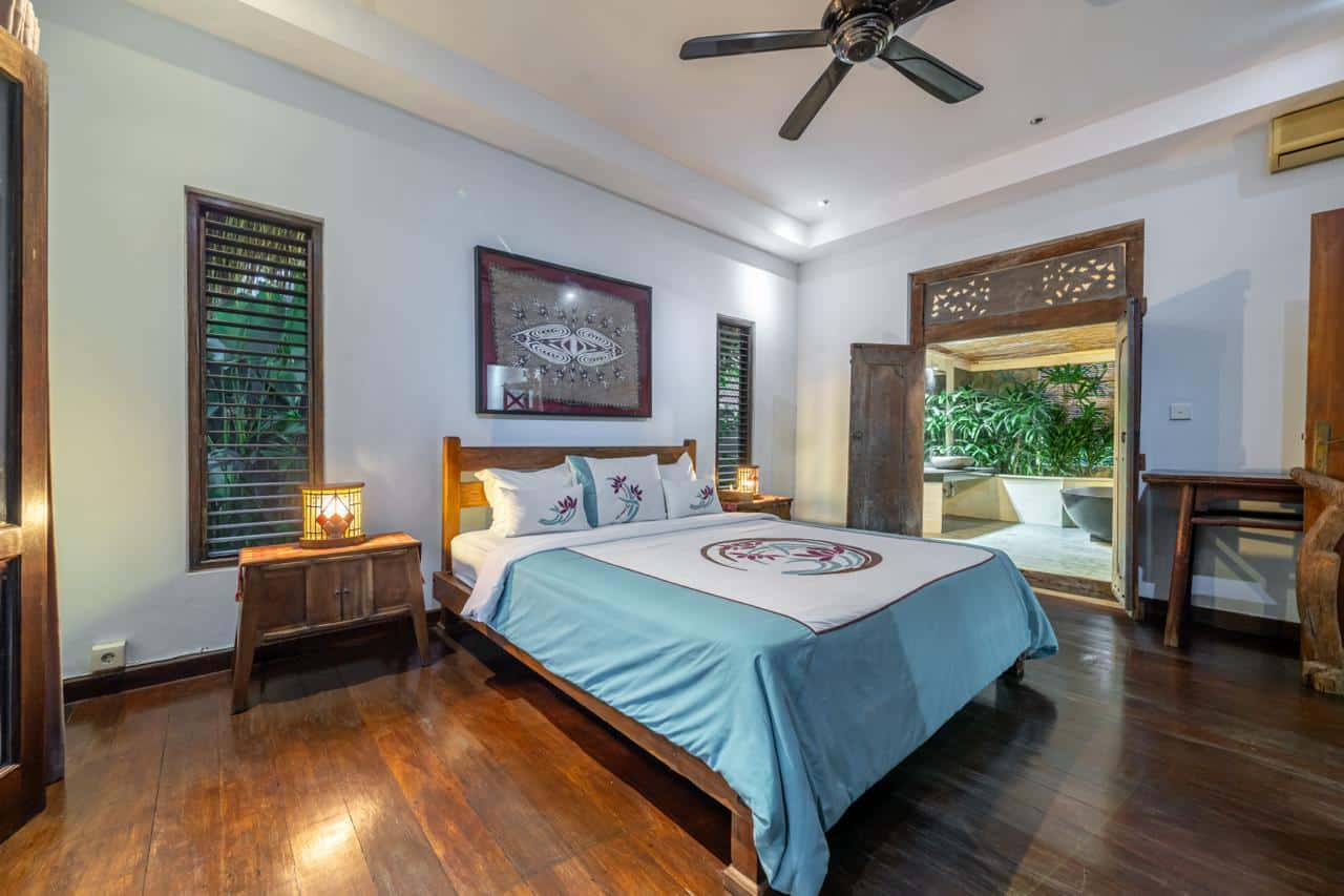 Cozy bedroom with wooden furniture and garden view.