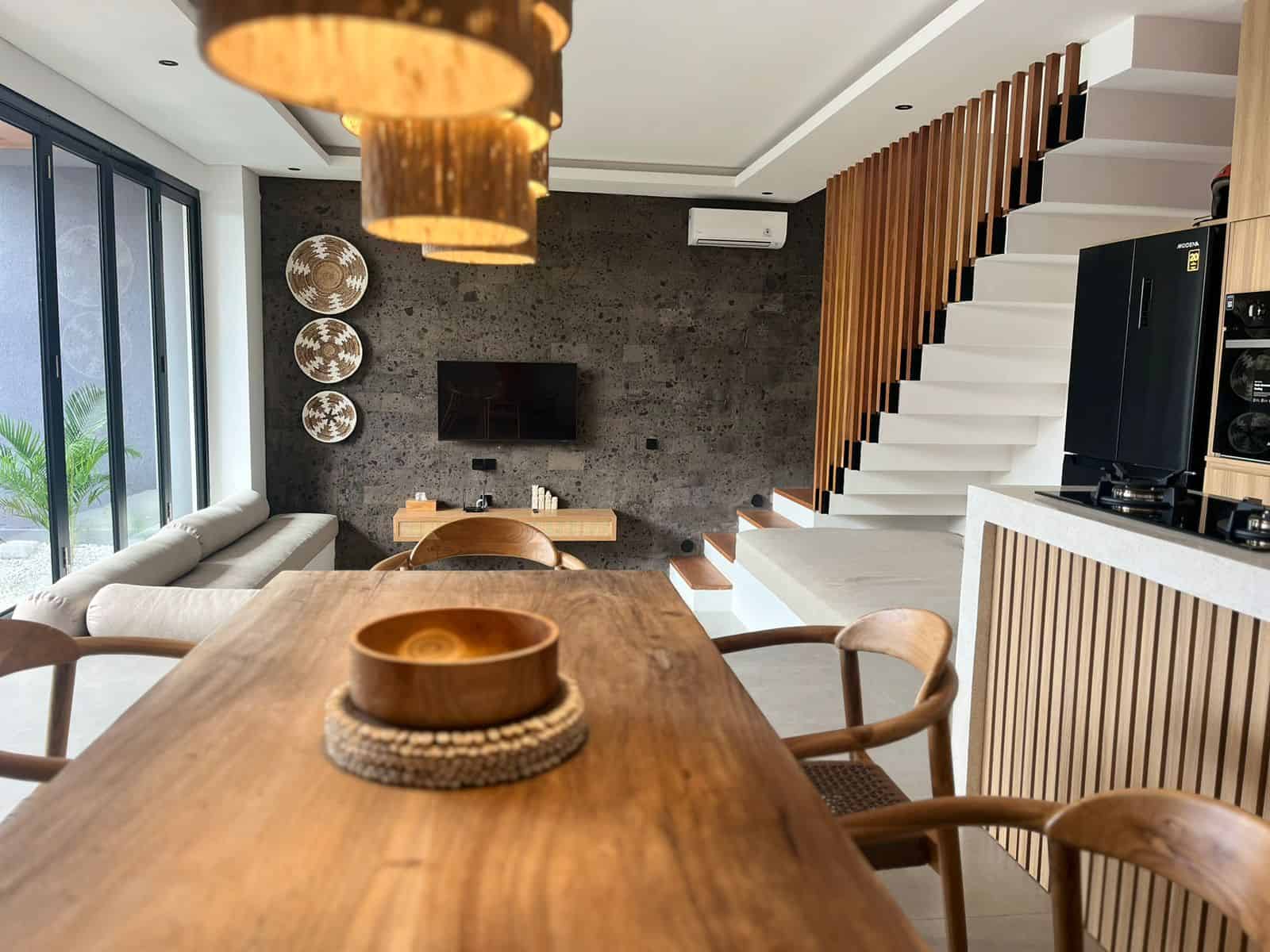 Modern living space with wooden furniture and staircase.