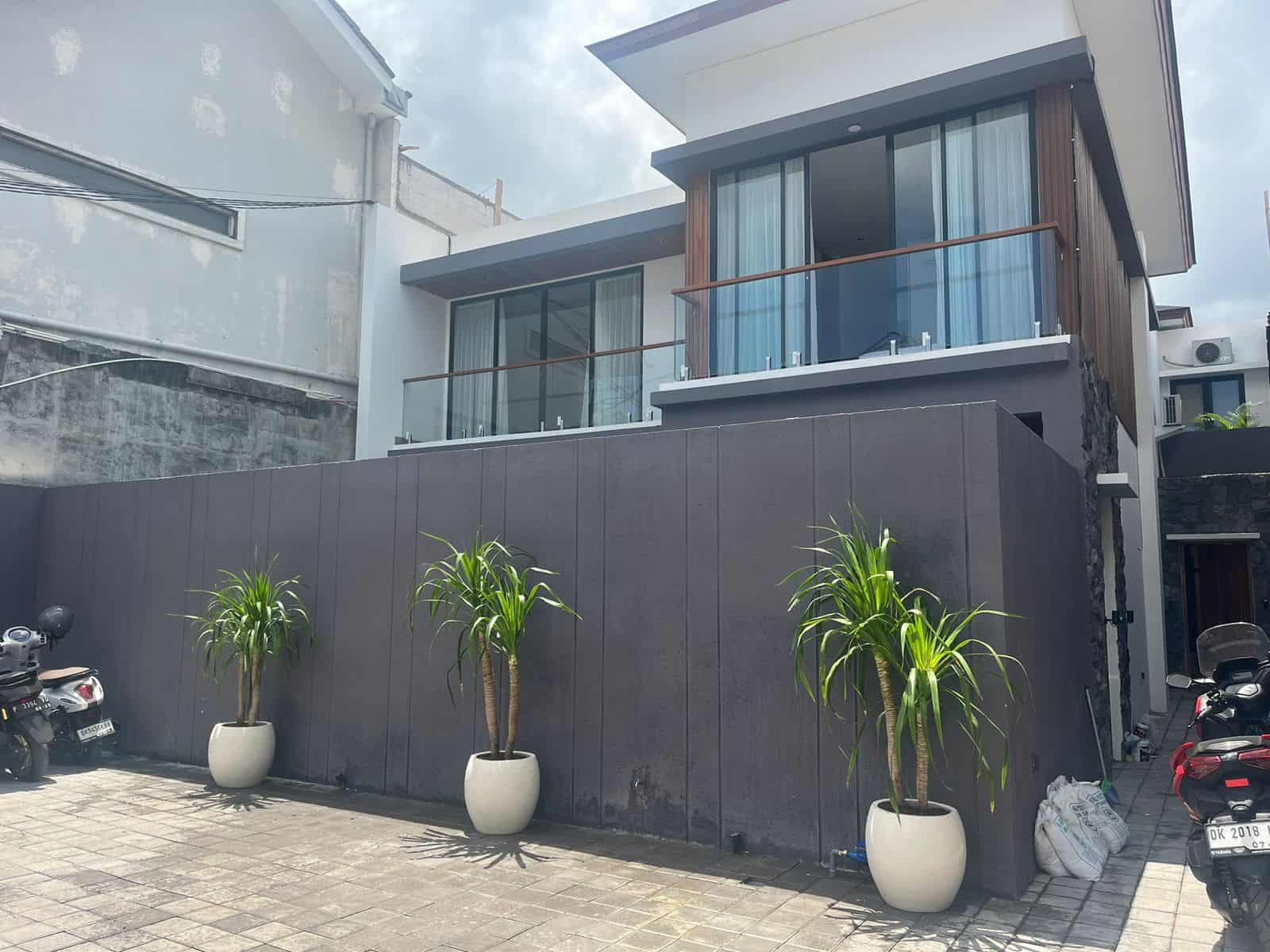 Modern house facade with potted plants and scooters