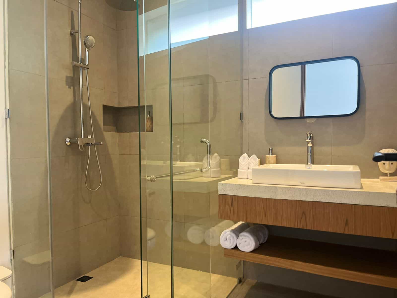Modern bathroom with glass shower and sink.