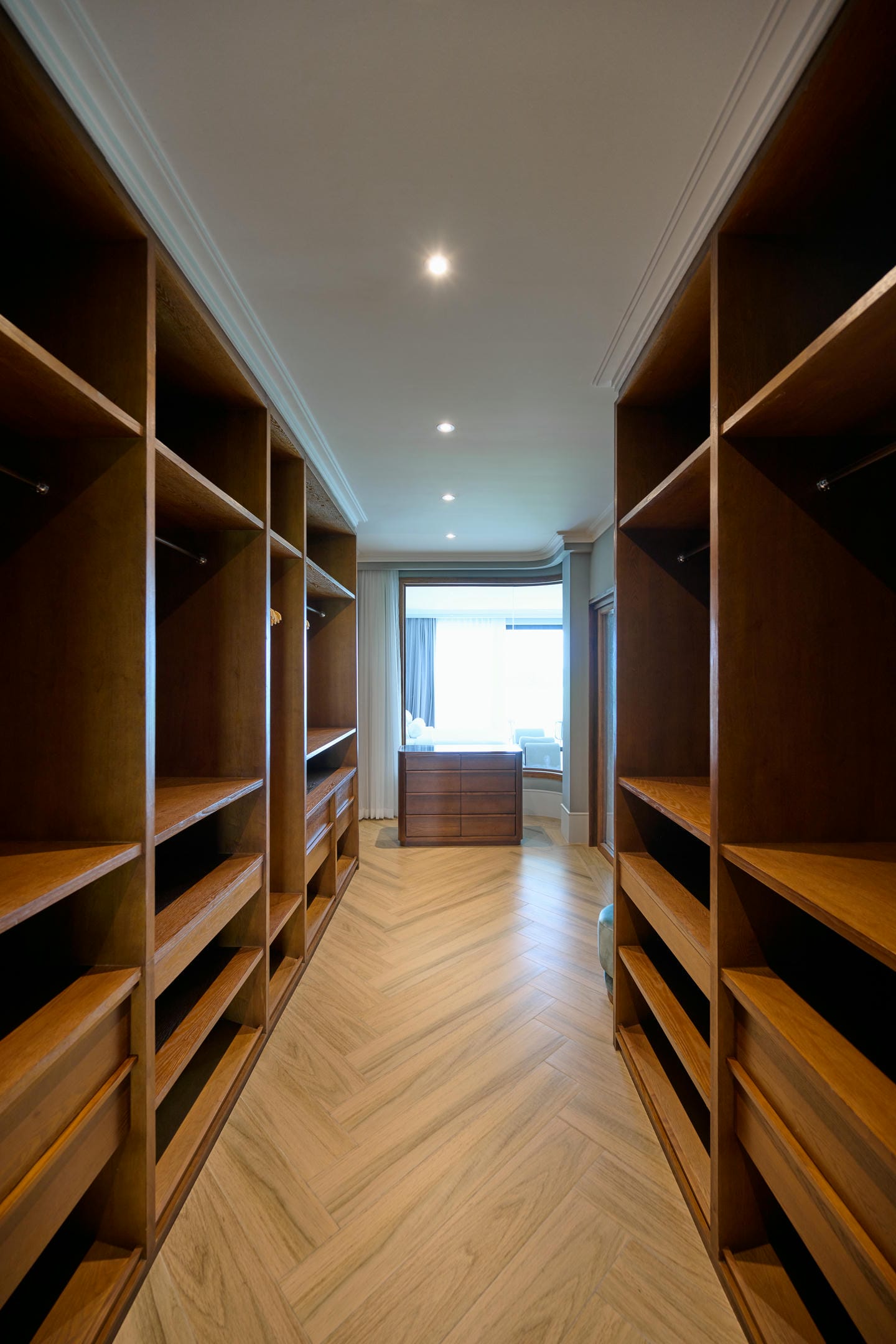Spacious wooden walk-in closet with natural light.