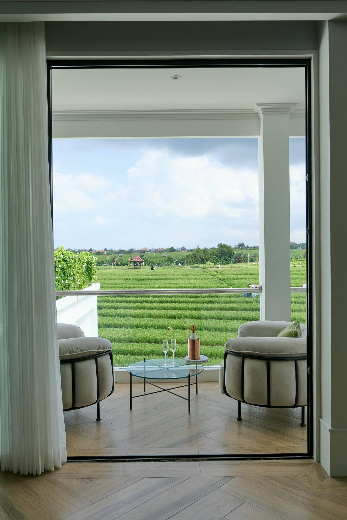 Balcony with chairs and view of rice fields.