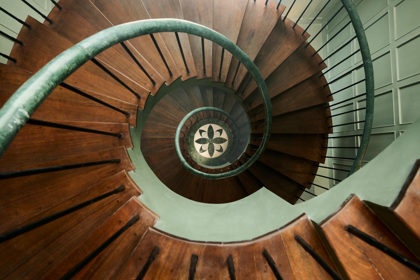 Spiral wooden staircase with intricate design view.