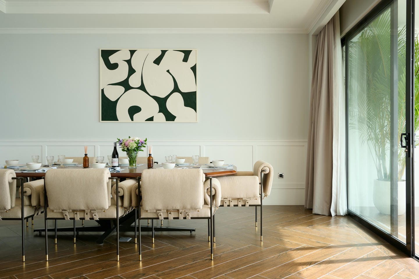 Modern dining room with abstract art and sliding doors.