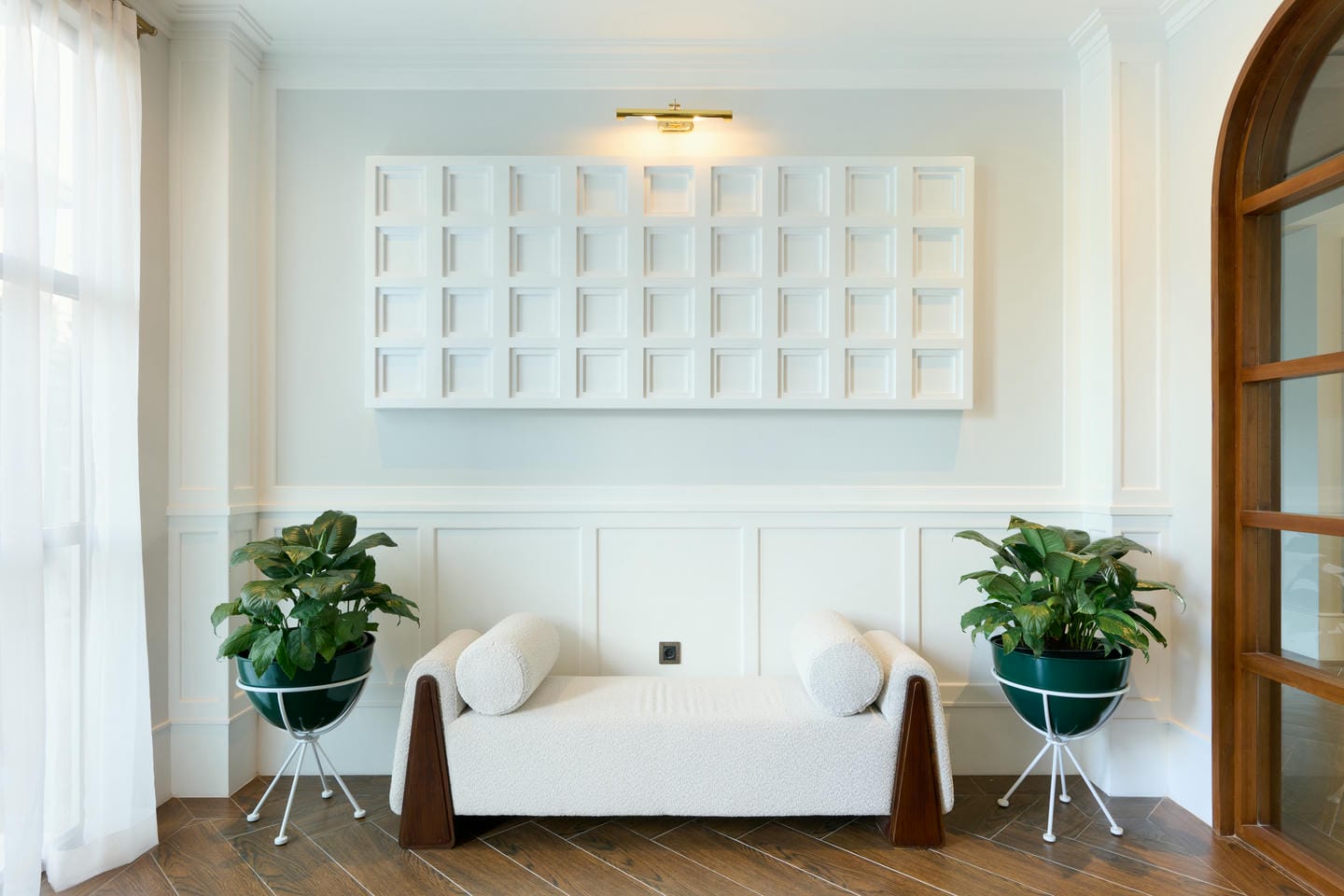 Modern seating area with plants and decorative panel.