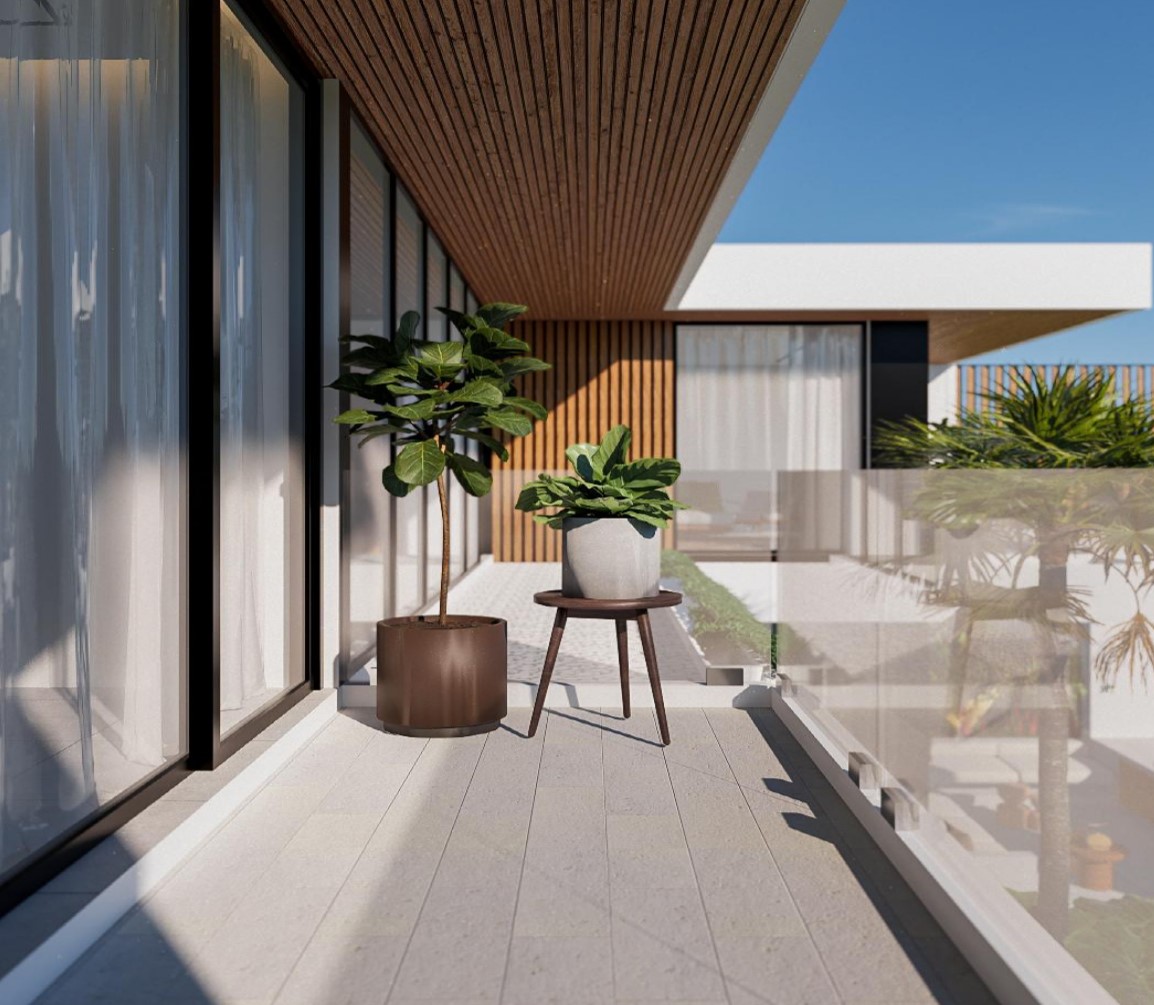 Modern balcony with potted plants and glass railing.