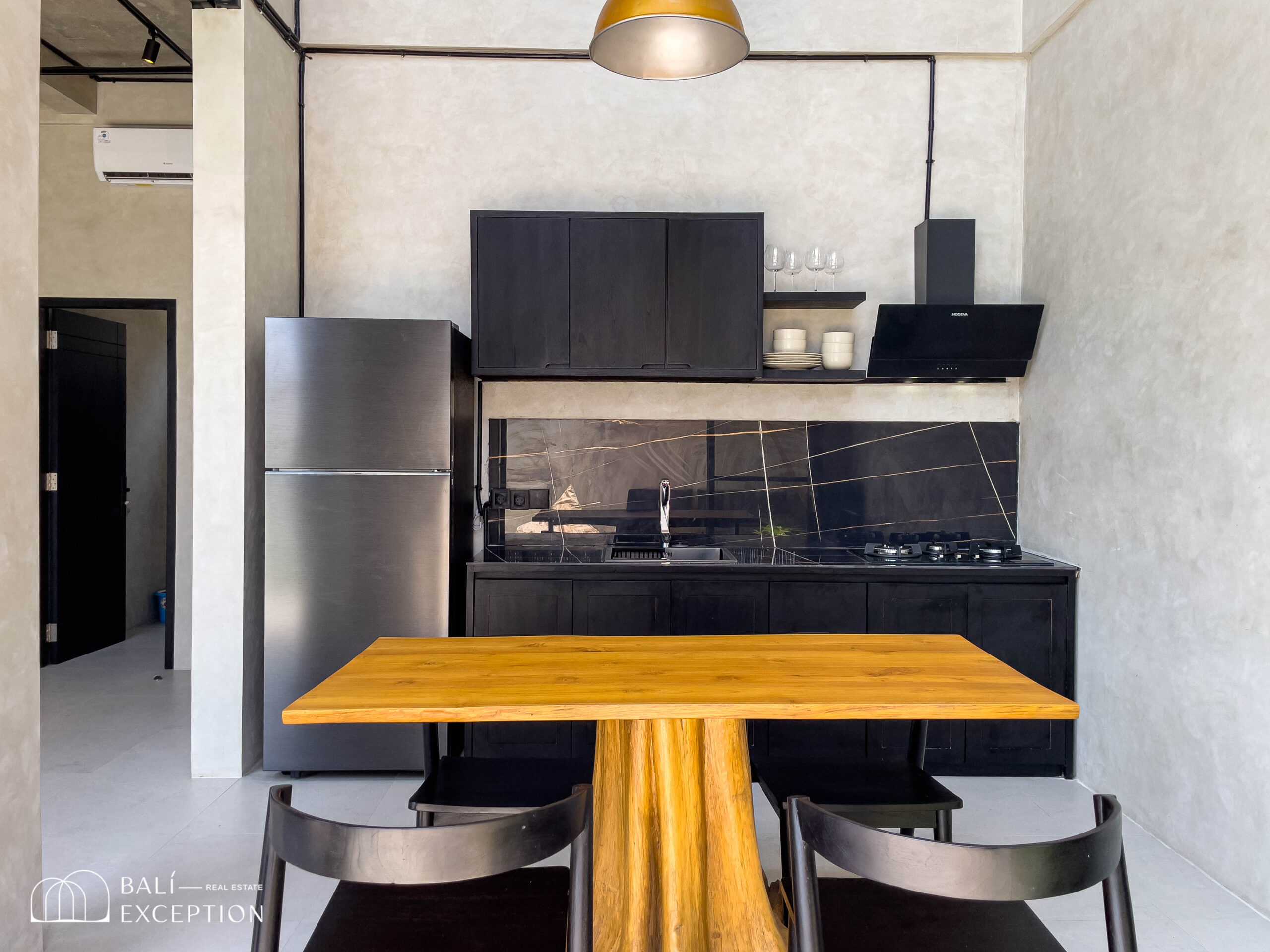 Modern black kitchen with wooden dining table.