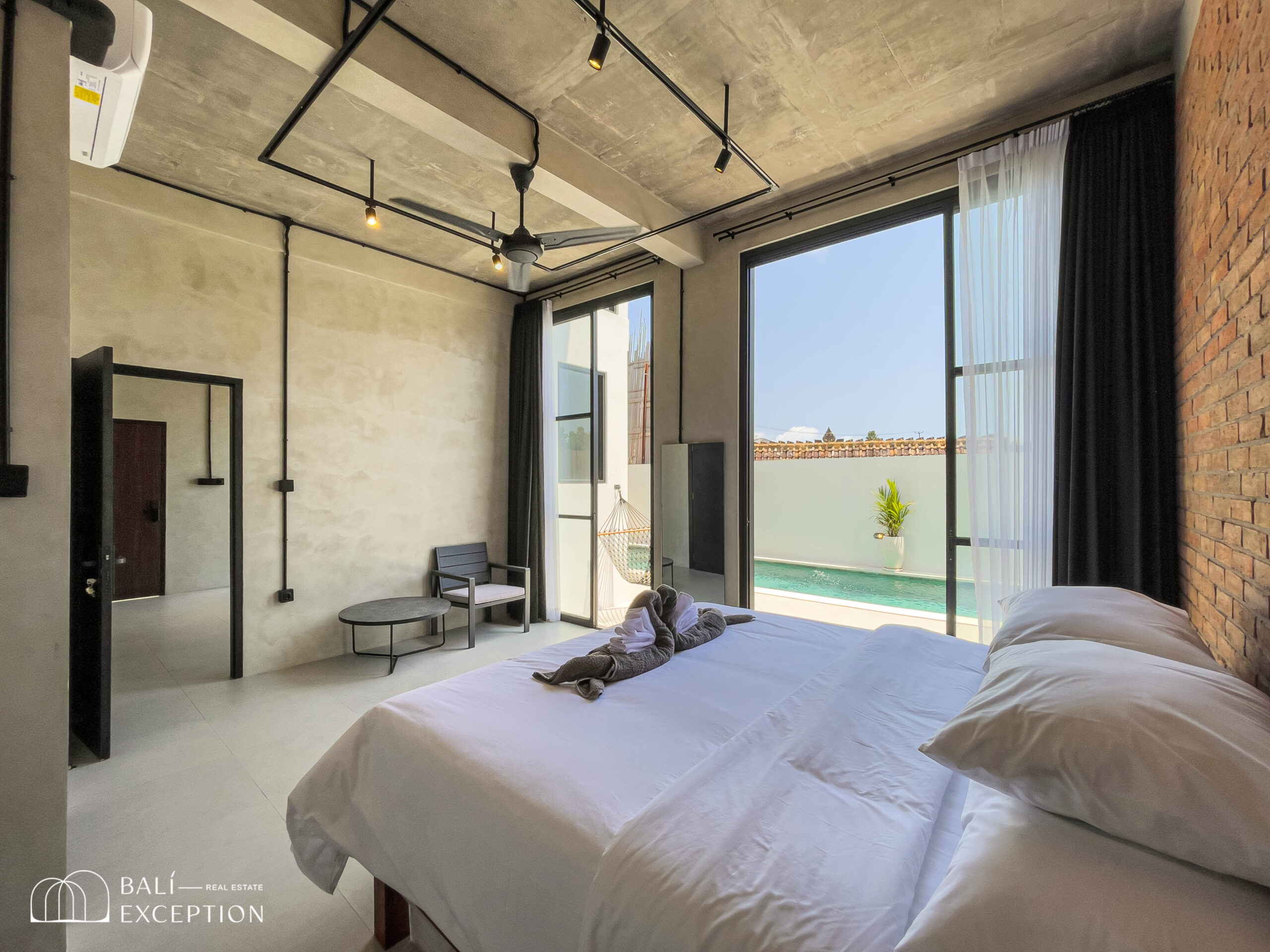 Modern bedroom with pool view and patio access.