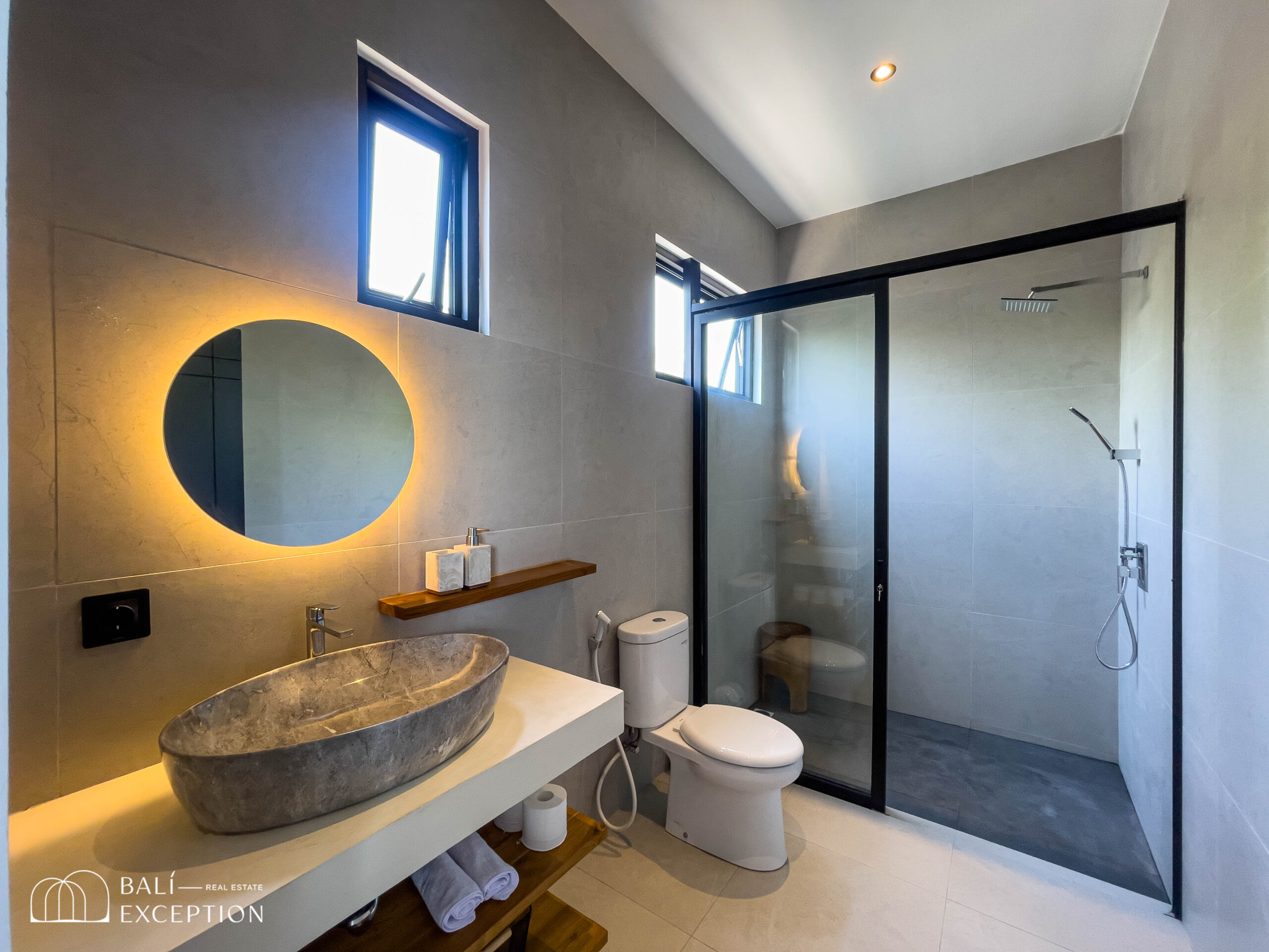 Modern bathroom with illuminated mirror and stone sink