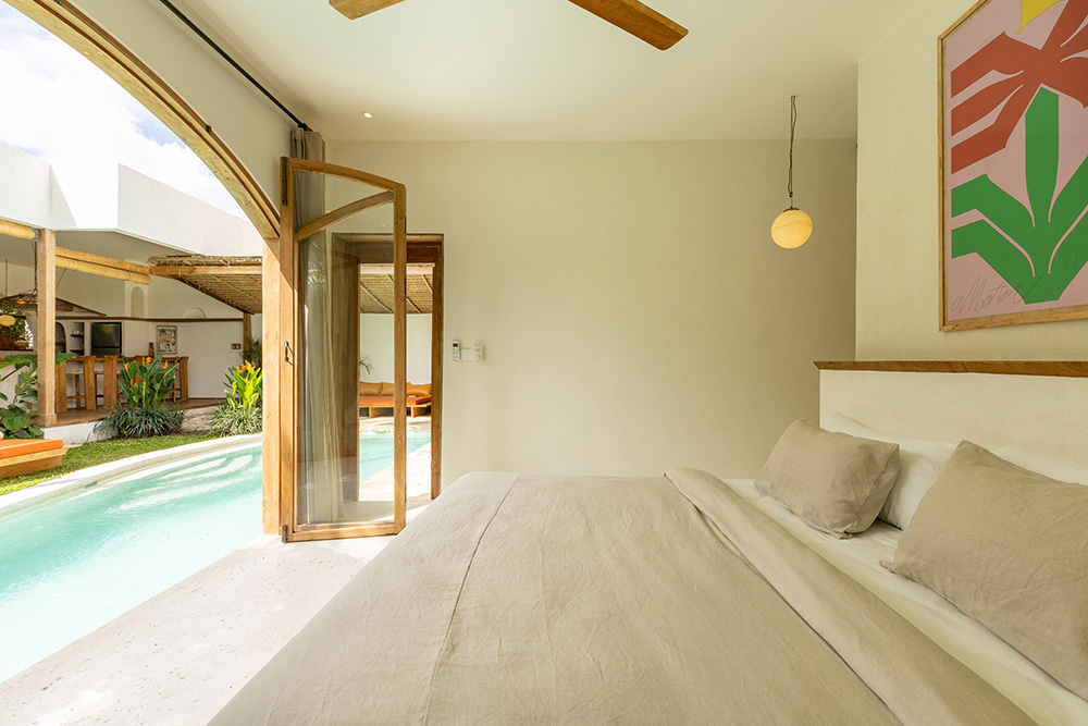 Cozy bedroom with pool view and modern decor.