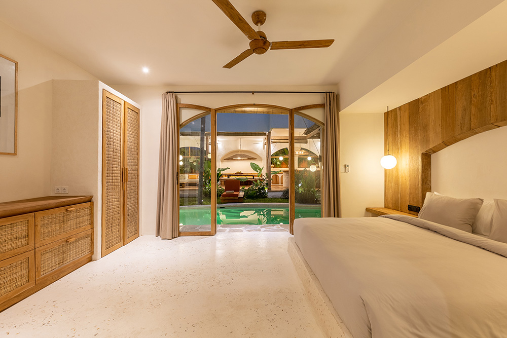 Luxury bedroom with pool view and modern decor.