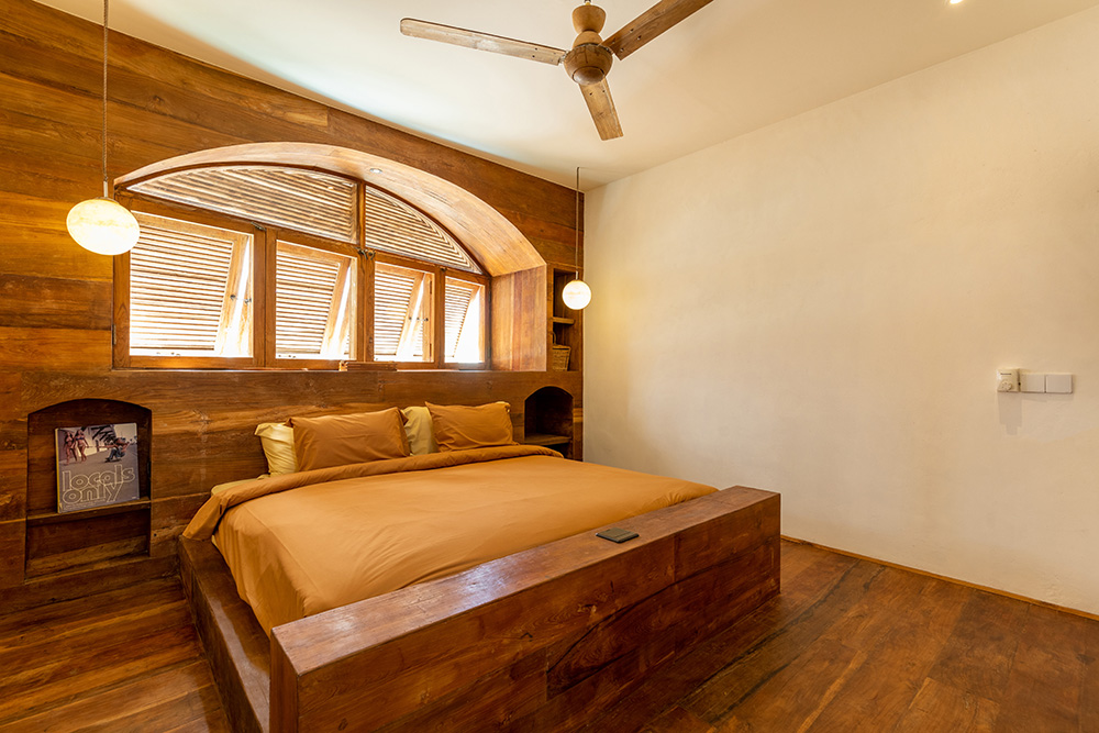 Rustic bedroom with wooden accents and large windows.