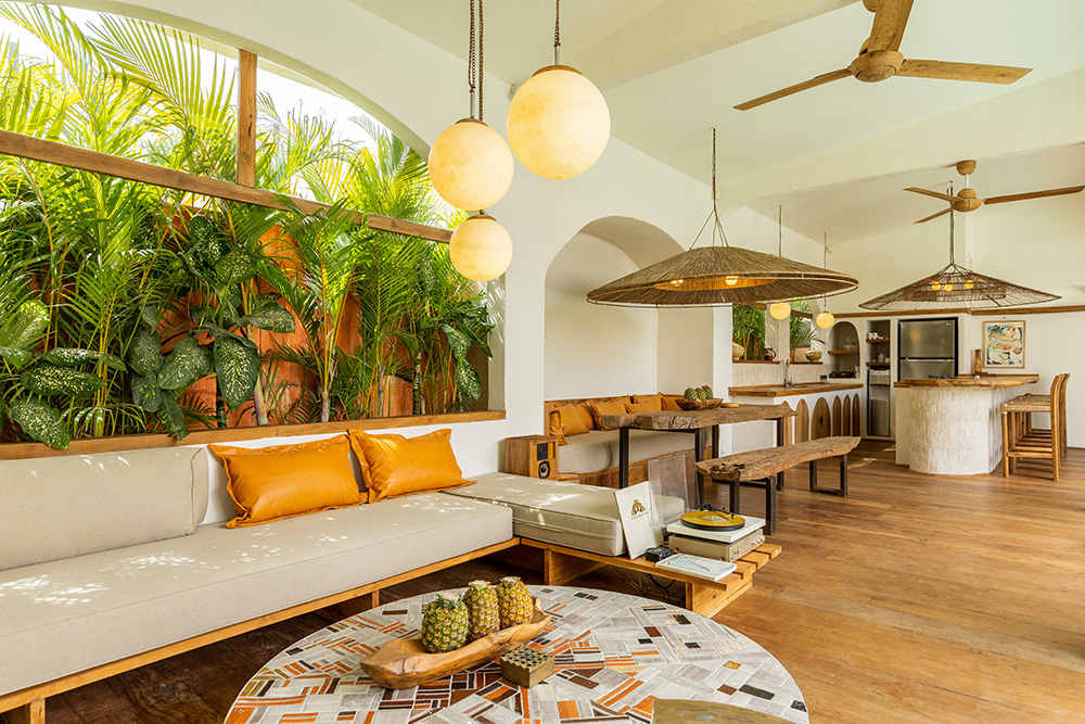 Modern tropical living room with plants and wood accents.