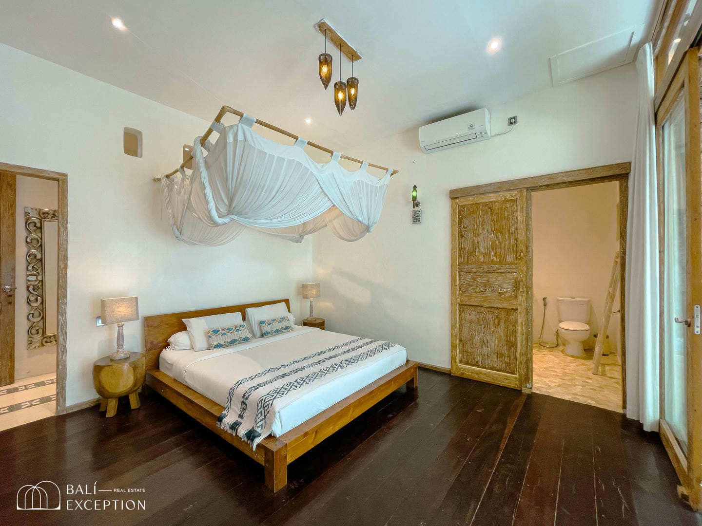 Cozy bedroom with wooden decor and bathroom access.