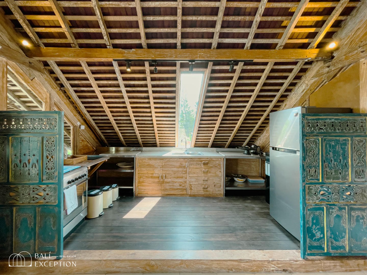 Rustic kitchen with wooden ceiling and modern appliances.