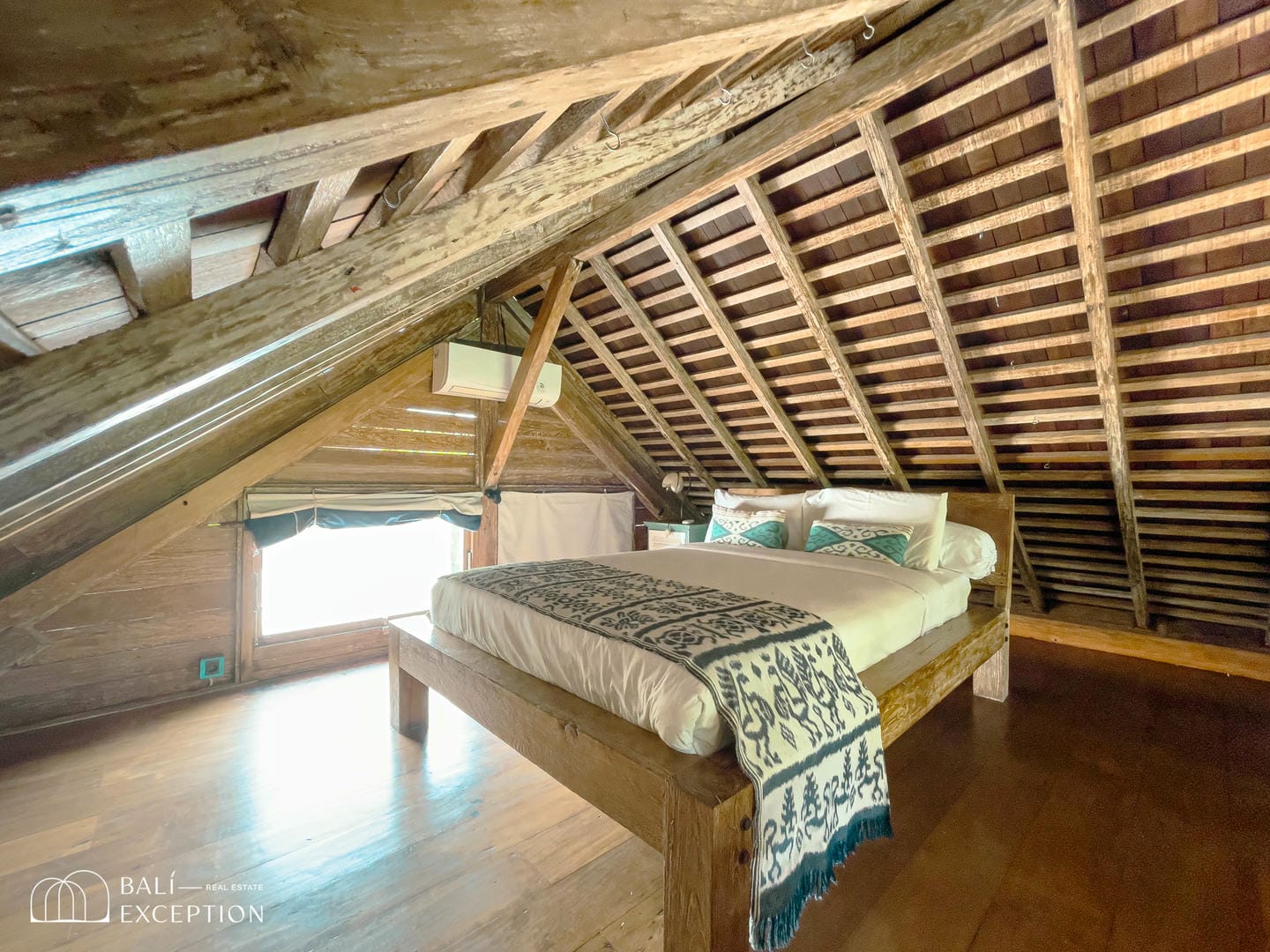 Rustic wooden attic bedroom with sunlight.