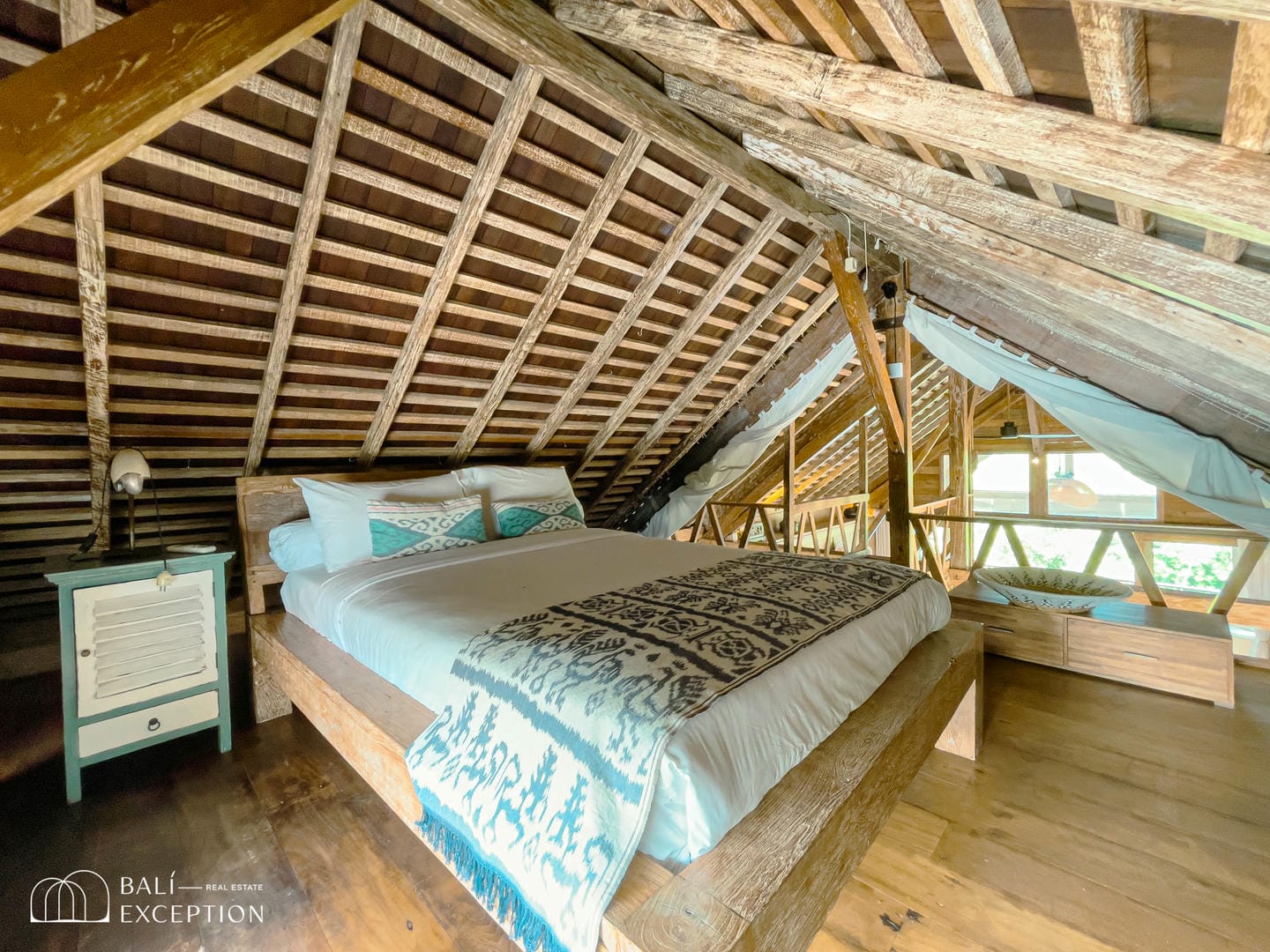 Cozy attic bedroom with wooden beams and decor.