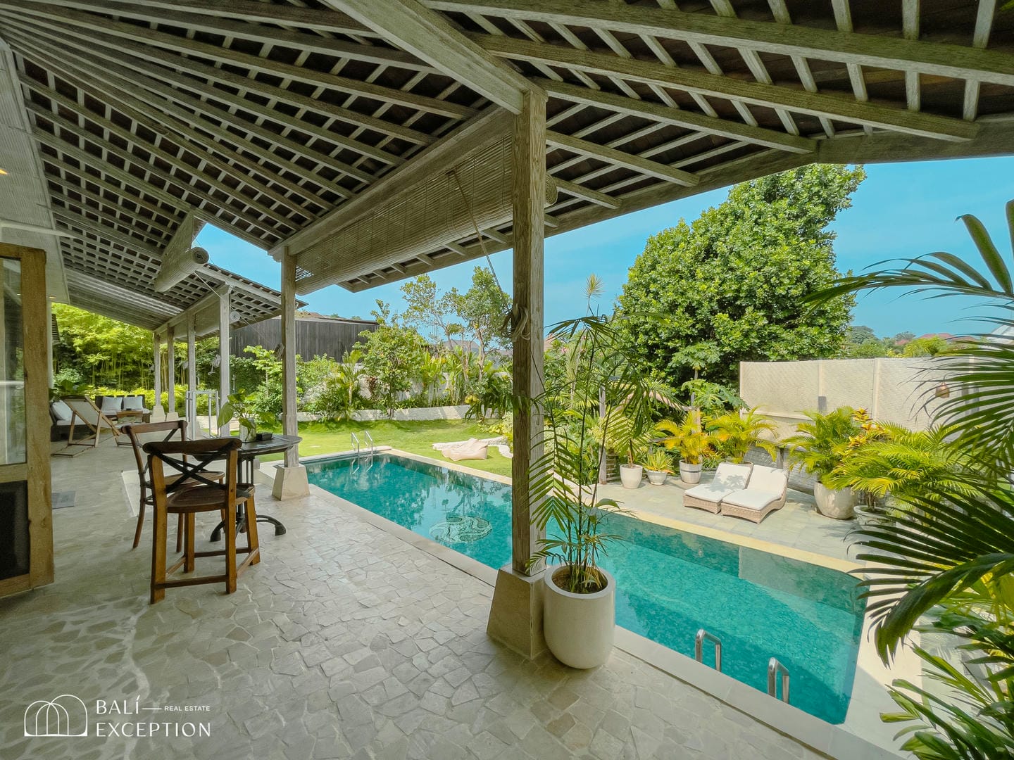Luxury villa patio with pool and garden view.