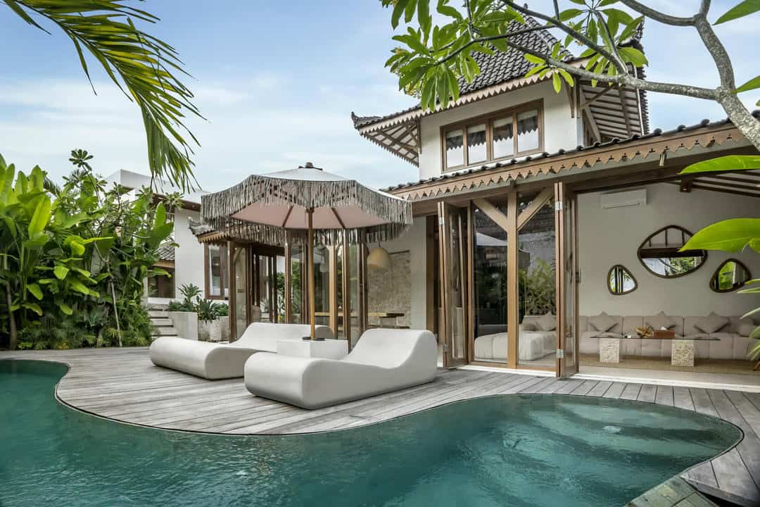 Luxury tropical villa with pool and sun loungers.