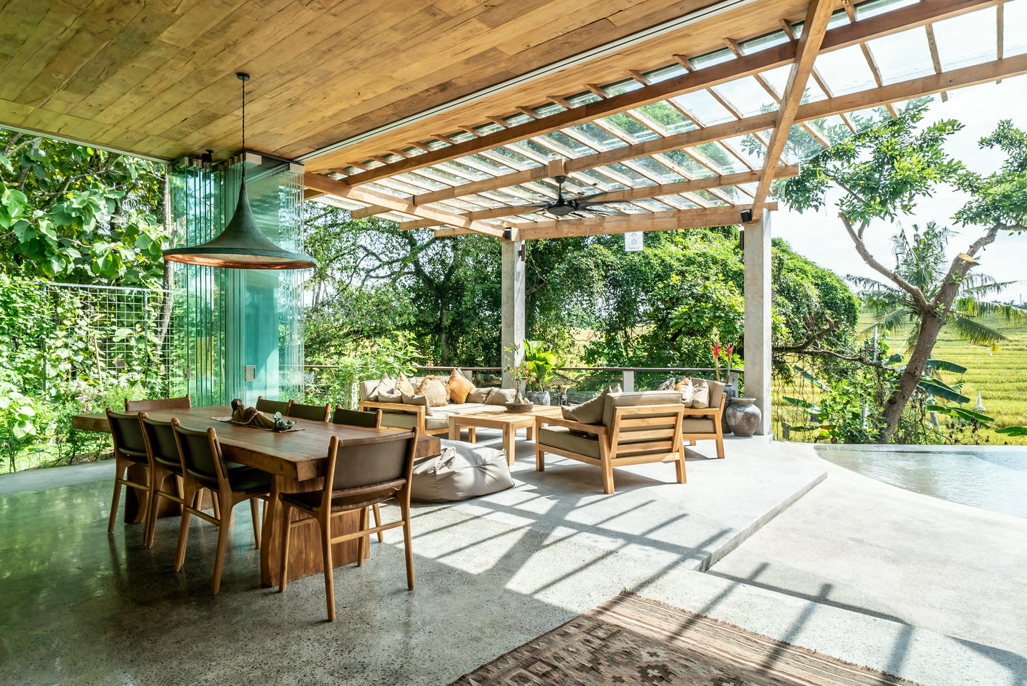 Open-air patio with wooden furniture and garden view