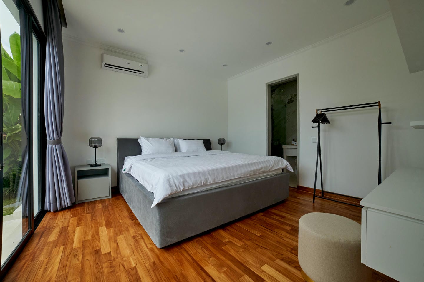 Modern bedroom with bed, desk, and open closet.