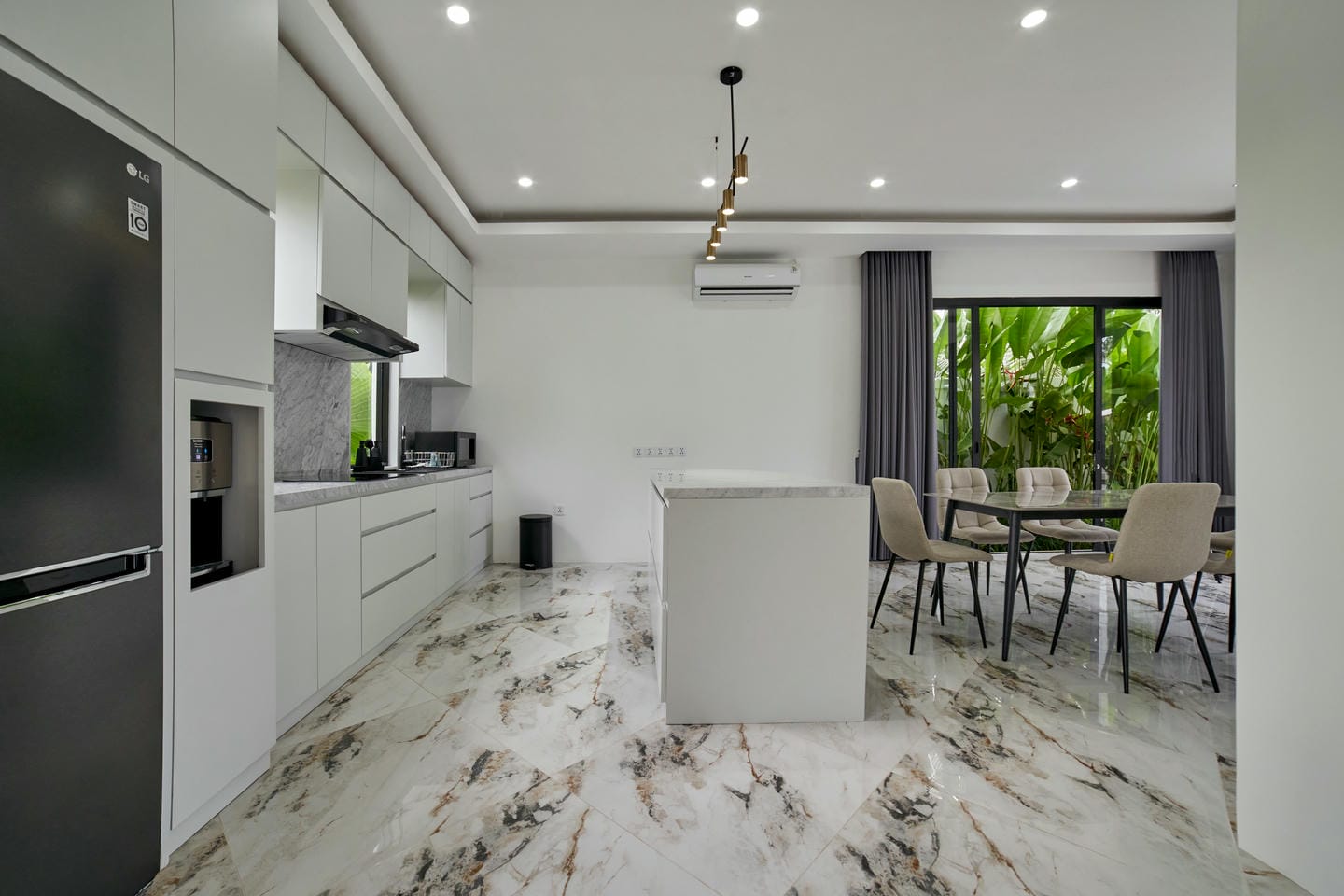 Modern kitchen and dining area with marble flooring.