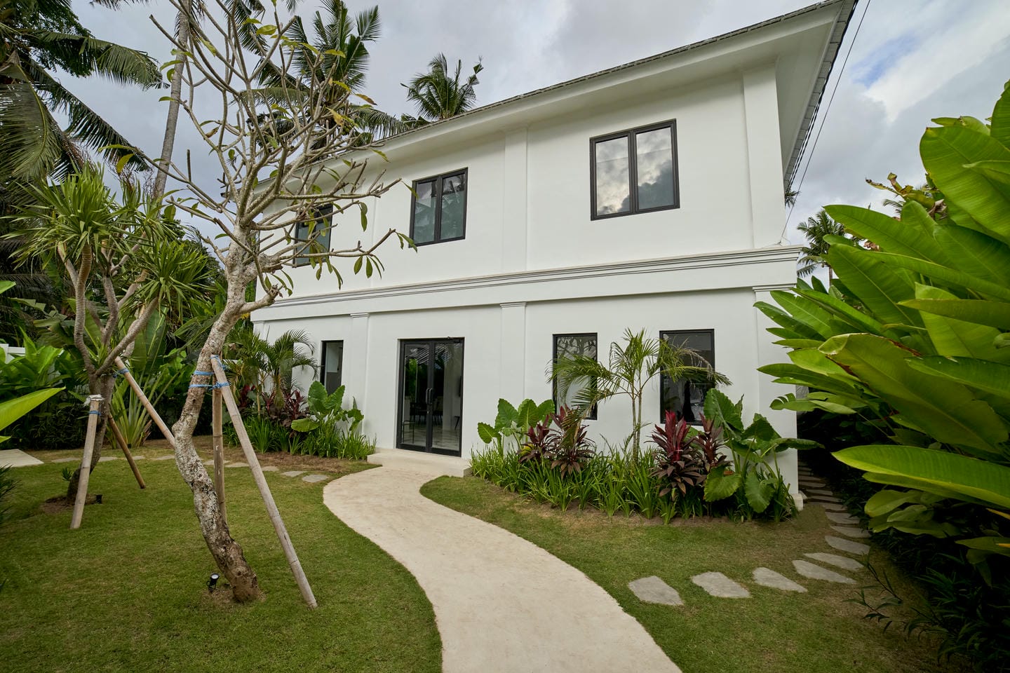 Modern two-story house with tropical garden