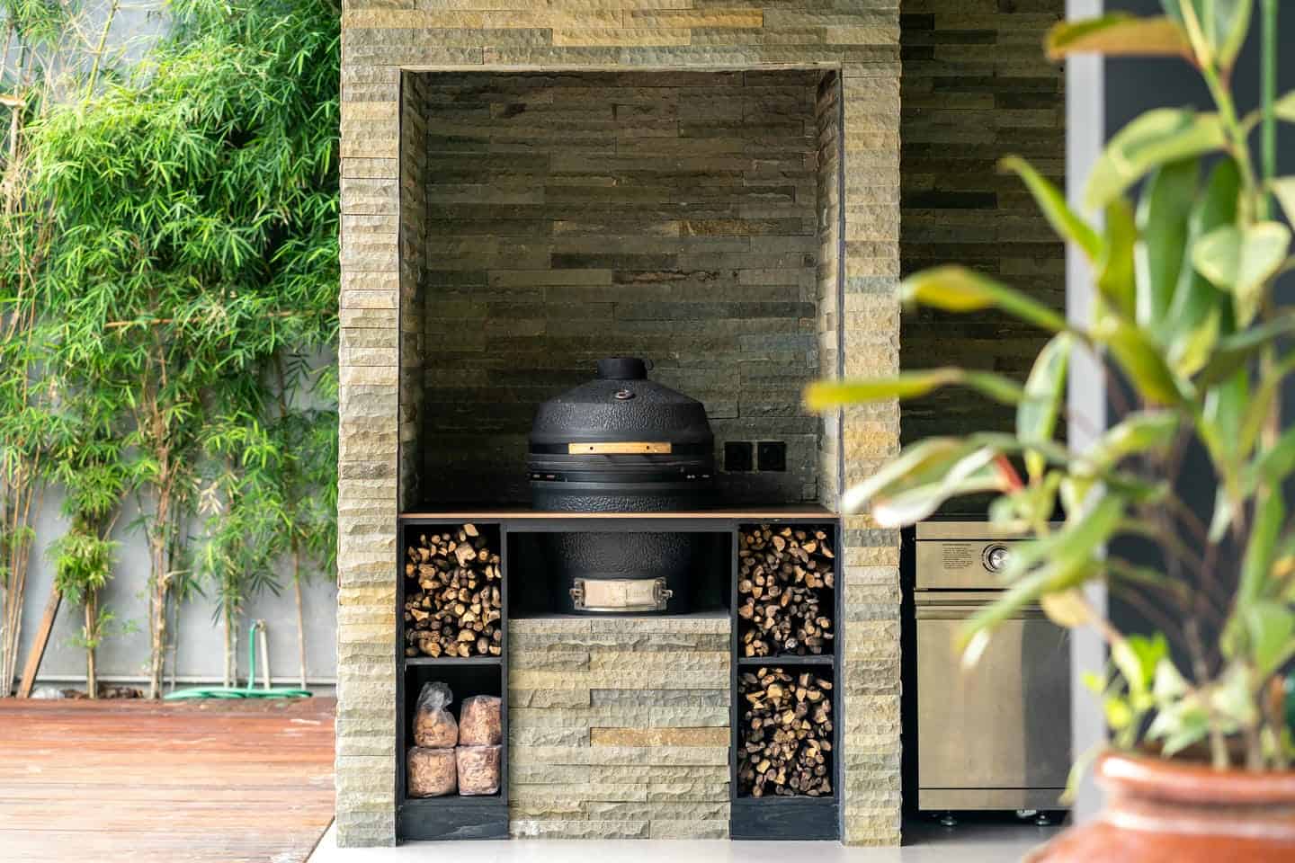 Outdoor kitchen with wood-fired oven and greenery