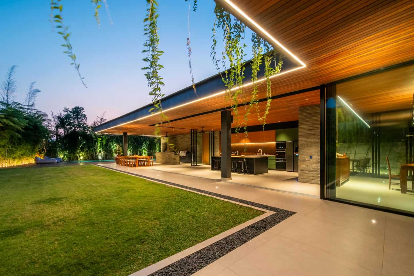 Modern open-air kitchen and patio at dusk