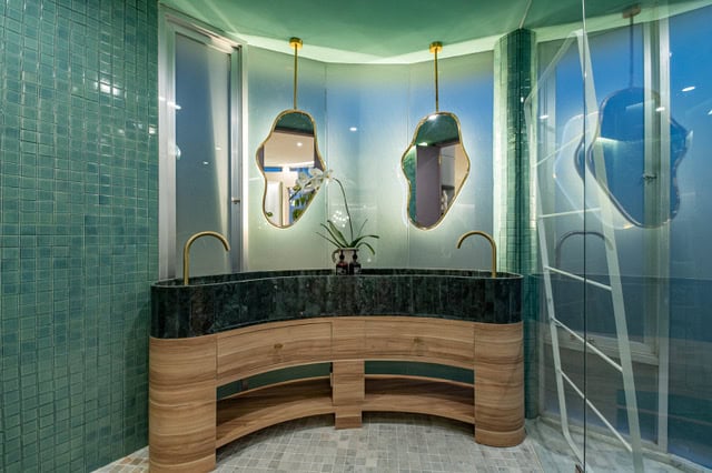 Modern bathroom with unique mirrors and green tiles
