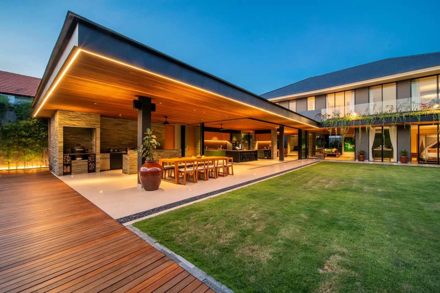 Modern house with open outdoor kitchen and dining area.