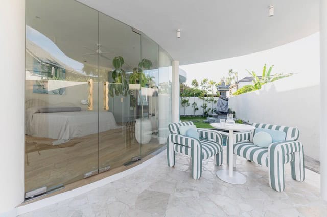 Modern patio with striped chairs and glass doors.