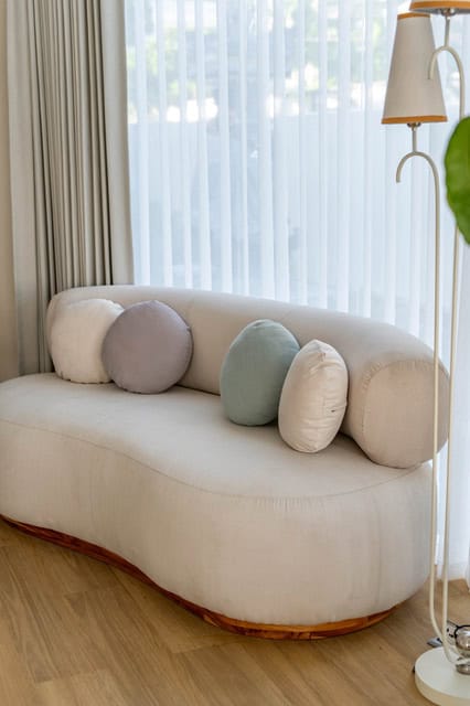 Modern sofa with decorative pillows near window