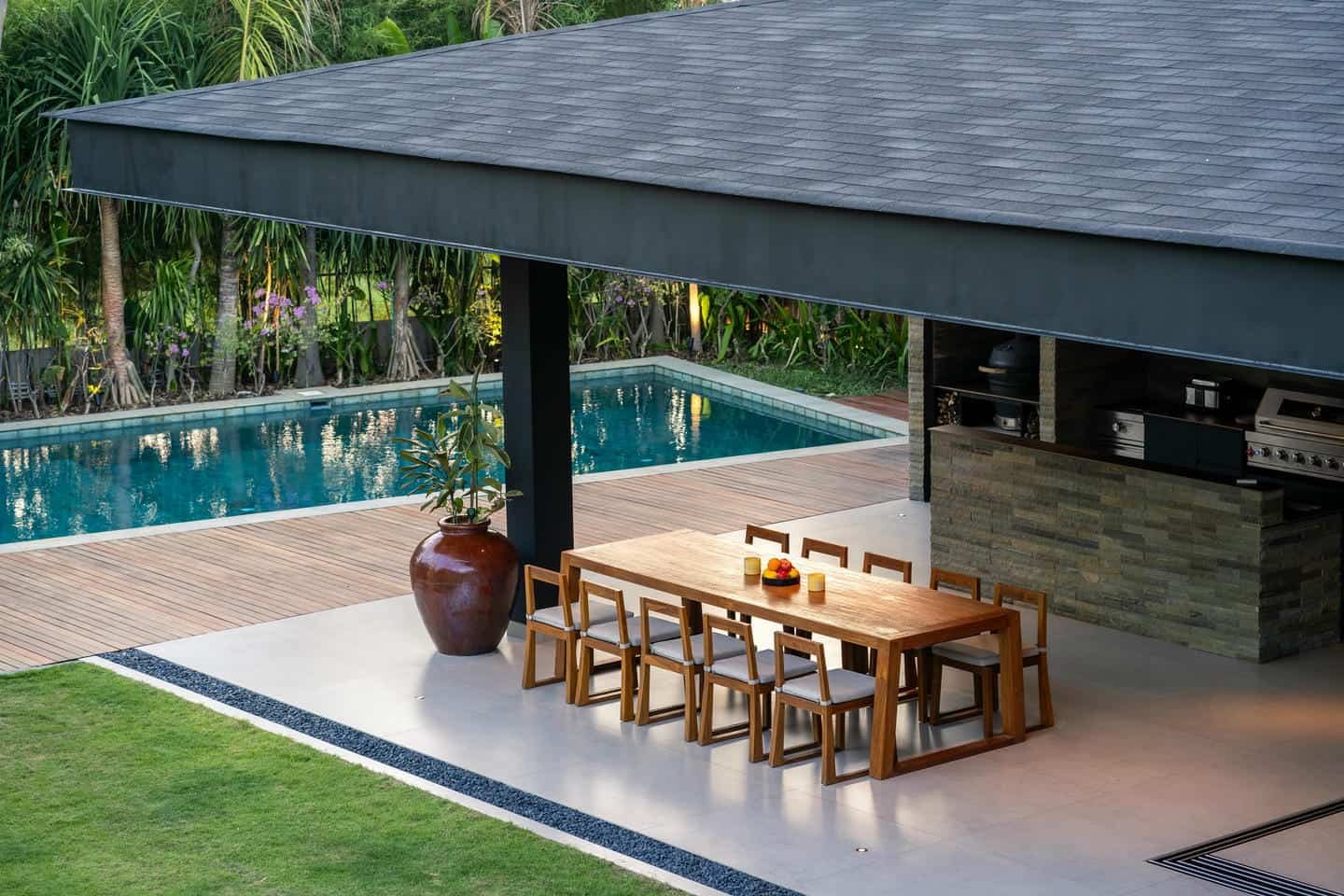 Modern patio with pool and outdoor dining area.