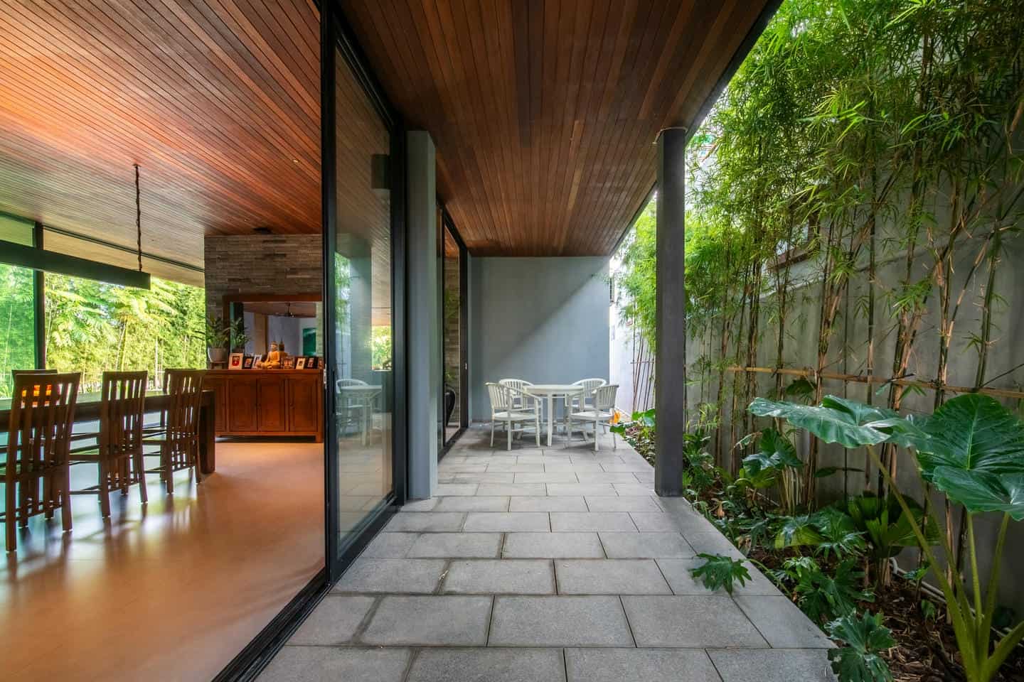 Modern patio with plants and dining table.