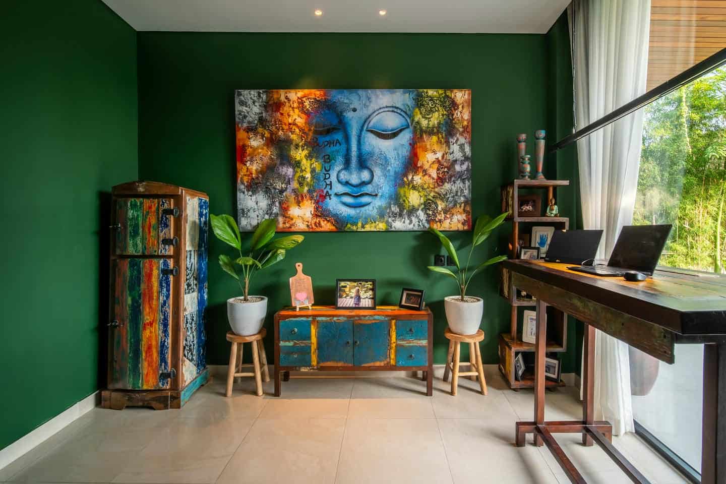 Colorful room with Buddha artwork and green walls.