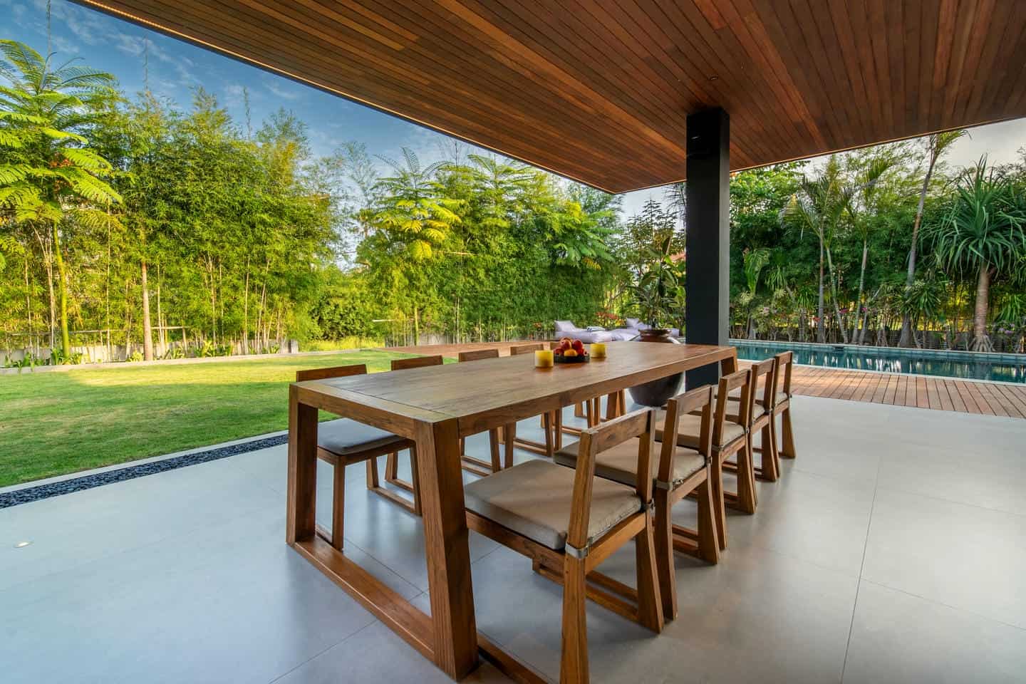 Outdoor patio with wooden table and lush garden