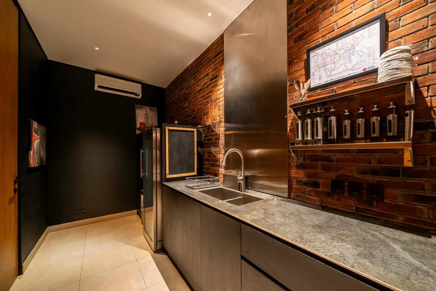 Modern industrial kitchen with brick walls and sink.
