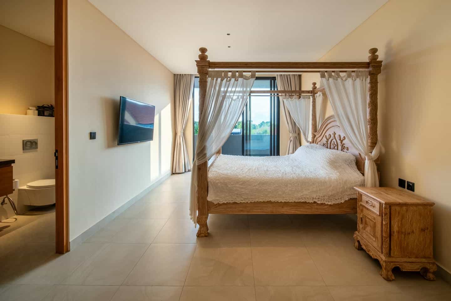 Elegant bedroom with canopy bed and modern decor.