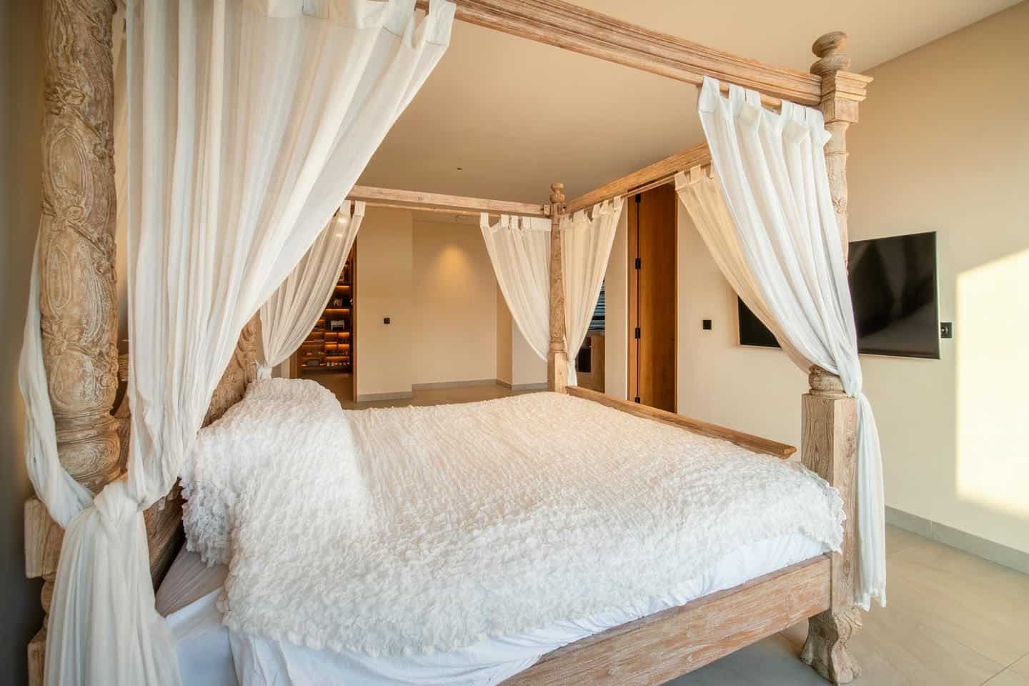 Luxurious four-poster bed with white canopy.