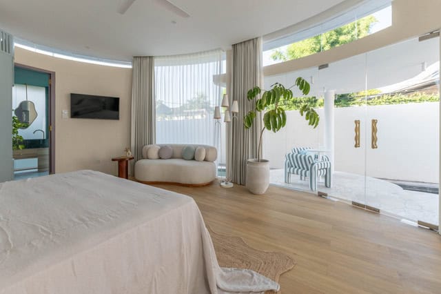 Modern bedroom with large windows and natural light.