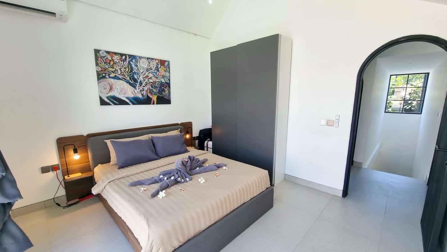 Modern bedroom with art and decorated bed.