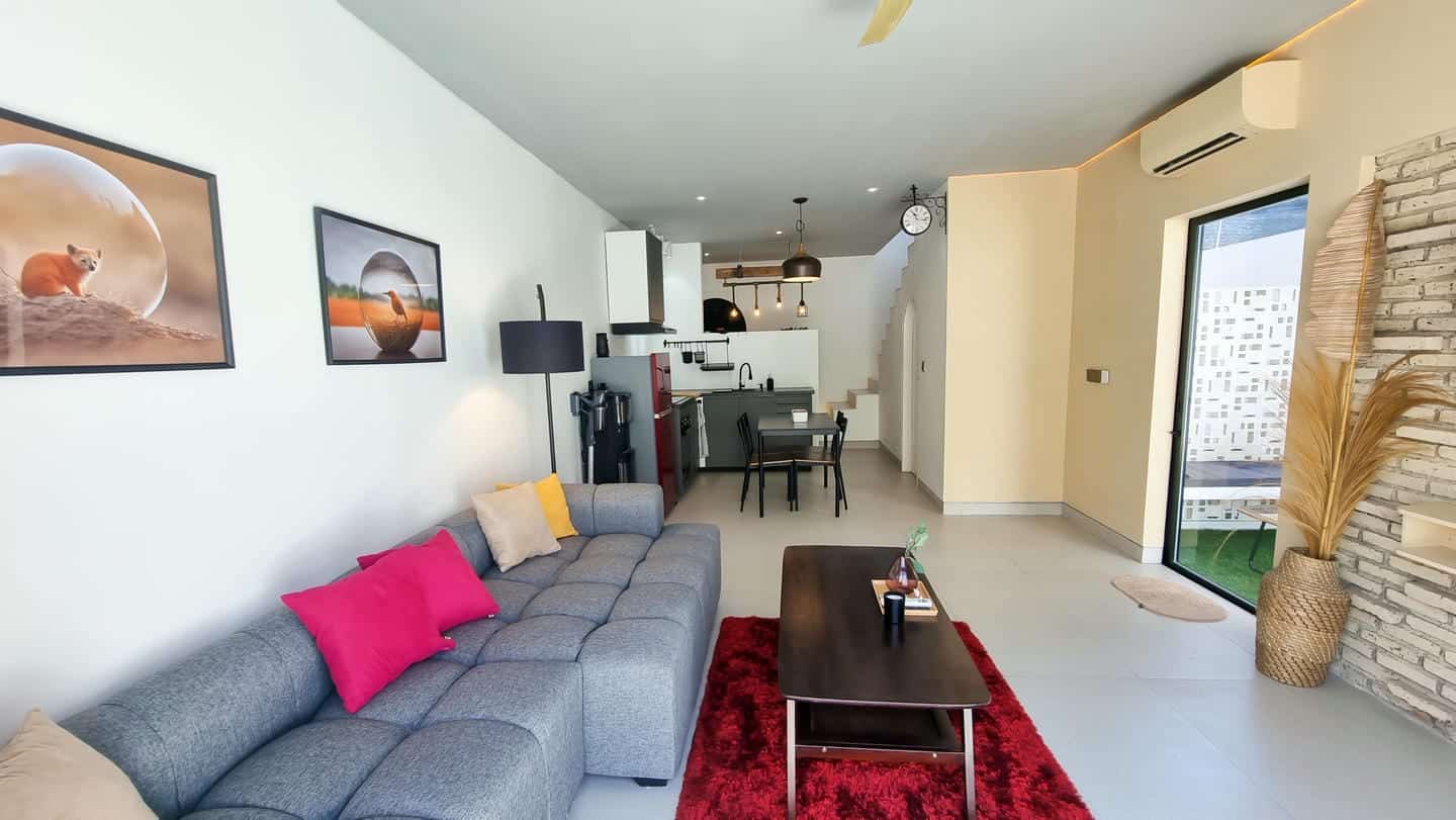 Modern living room with kitchen and dining area.