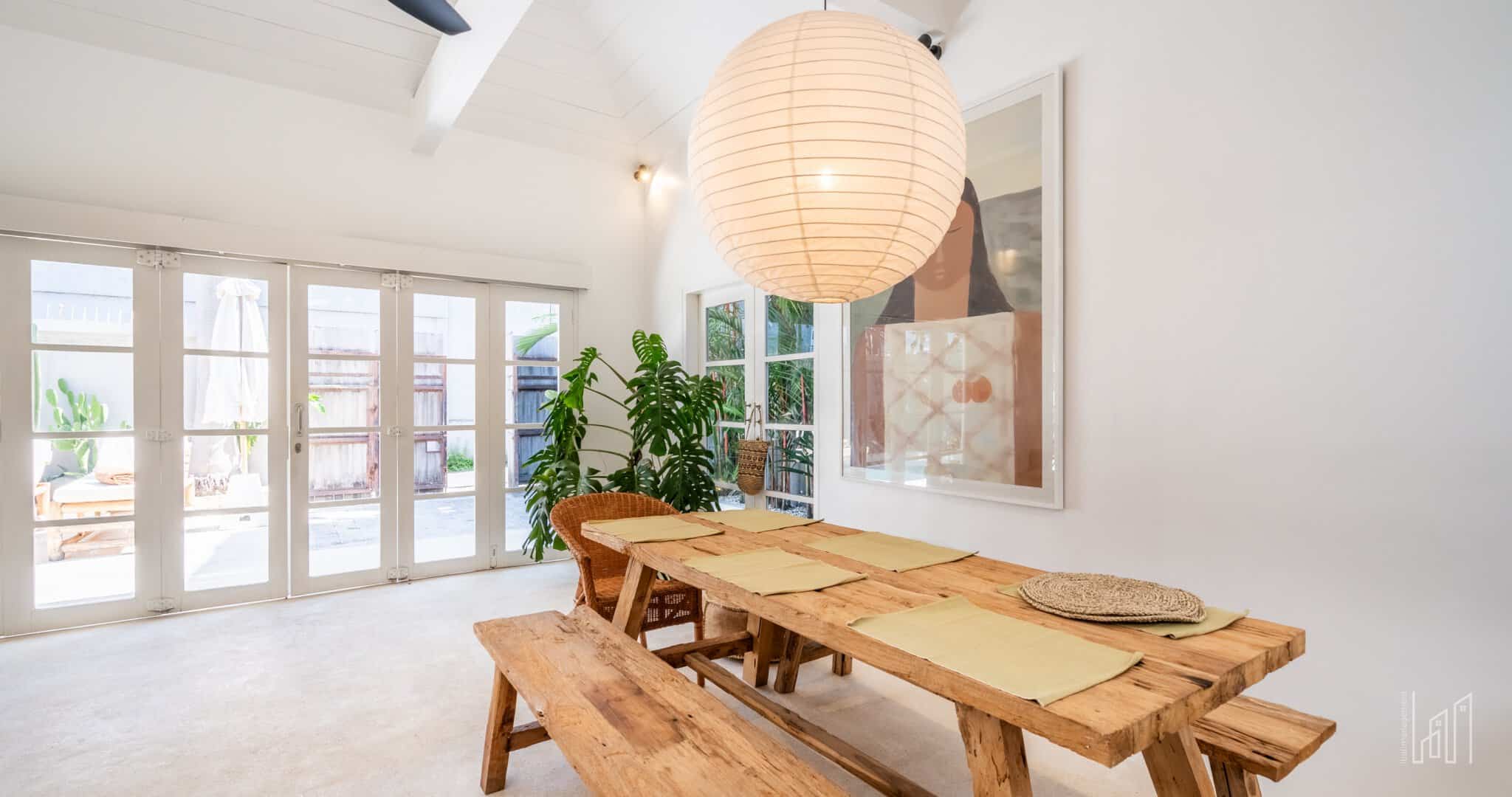 Bright dining room with wooden table, large lamp.